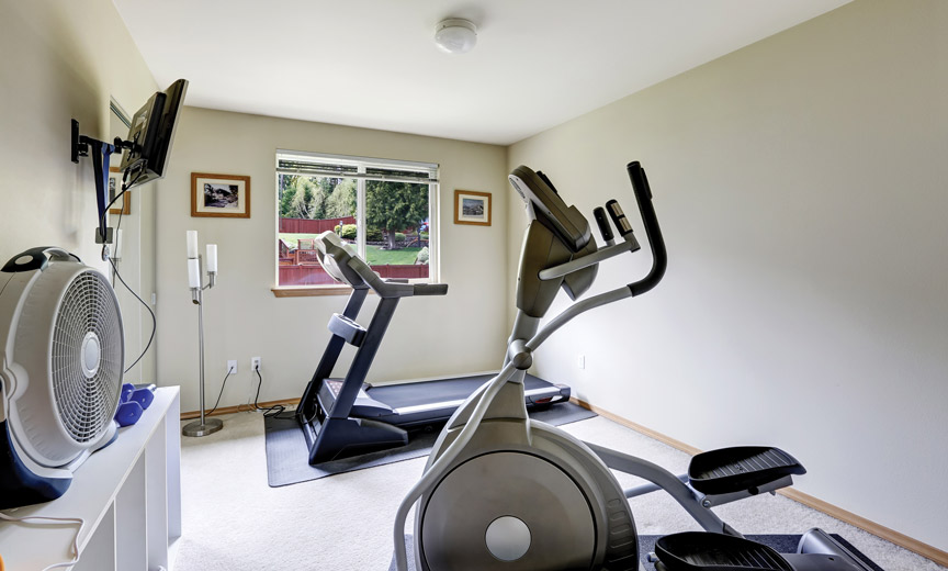 small home gym with a fan and cardio equipment