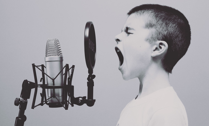 A Boy Sings Into a Microphone