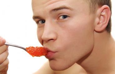 Cute guy eating caviar
